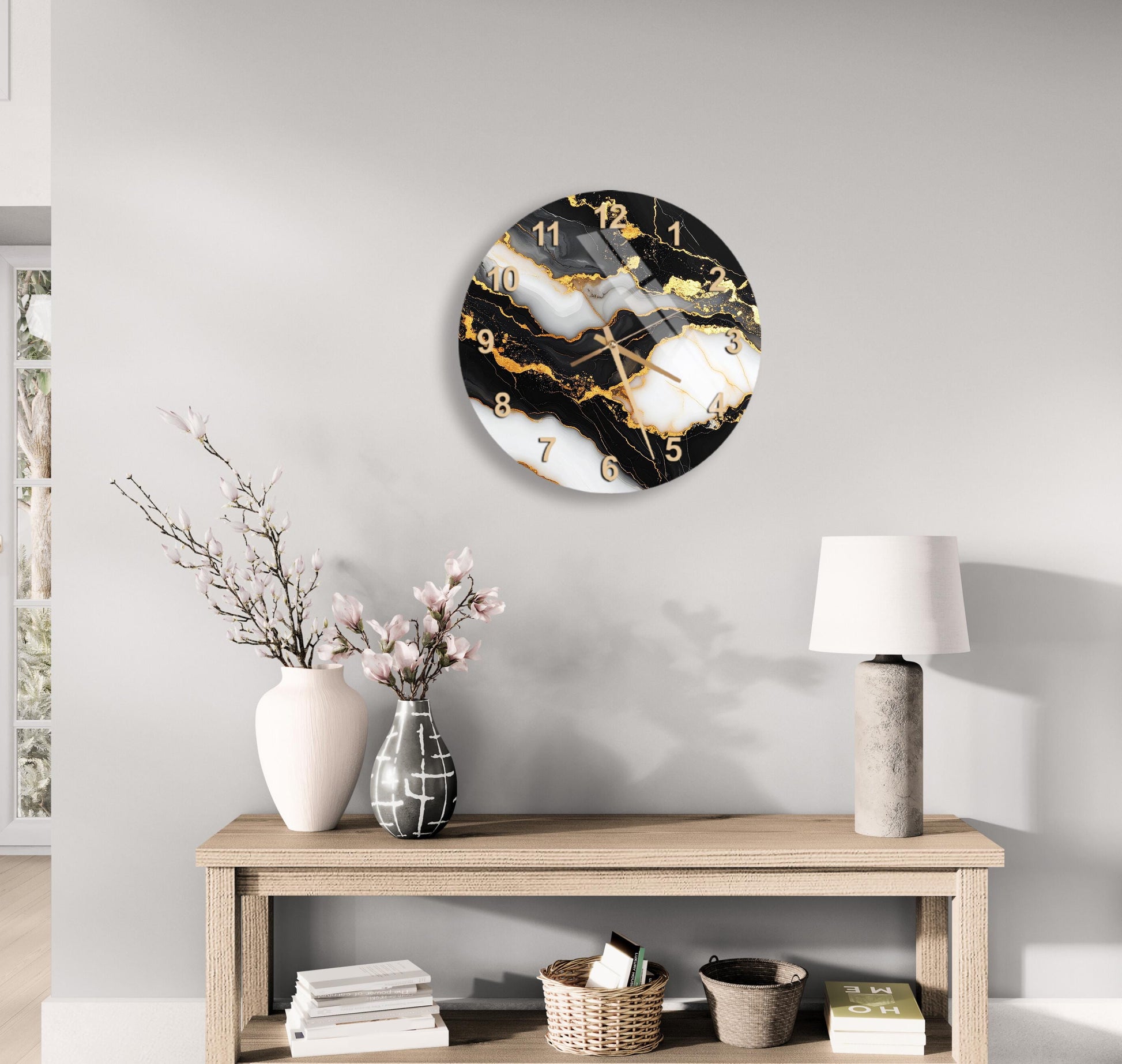 a modern living room with a wooden table displaying a clock, a vase with flowers, and a lamp. The clock has a black and white marble design with gold accents, and the table is set against a gray wall.