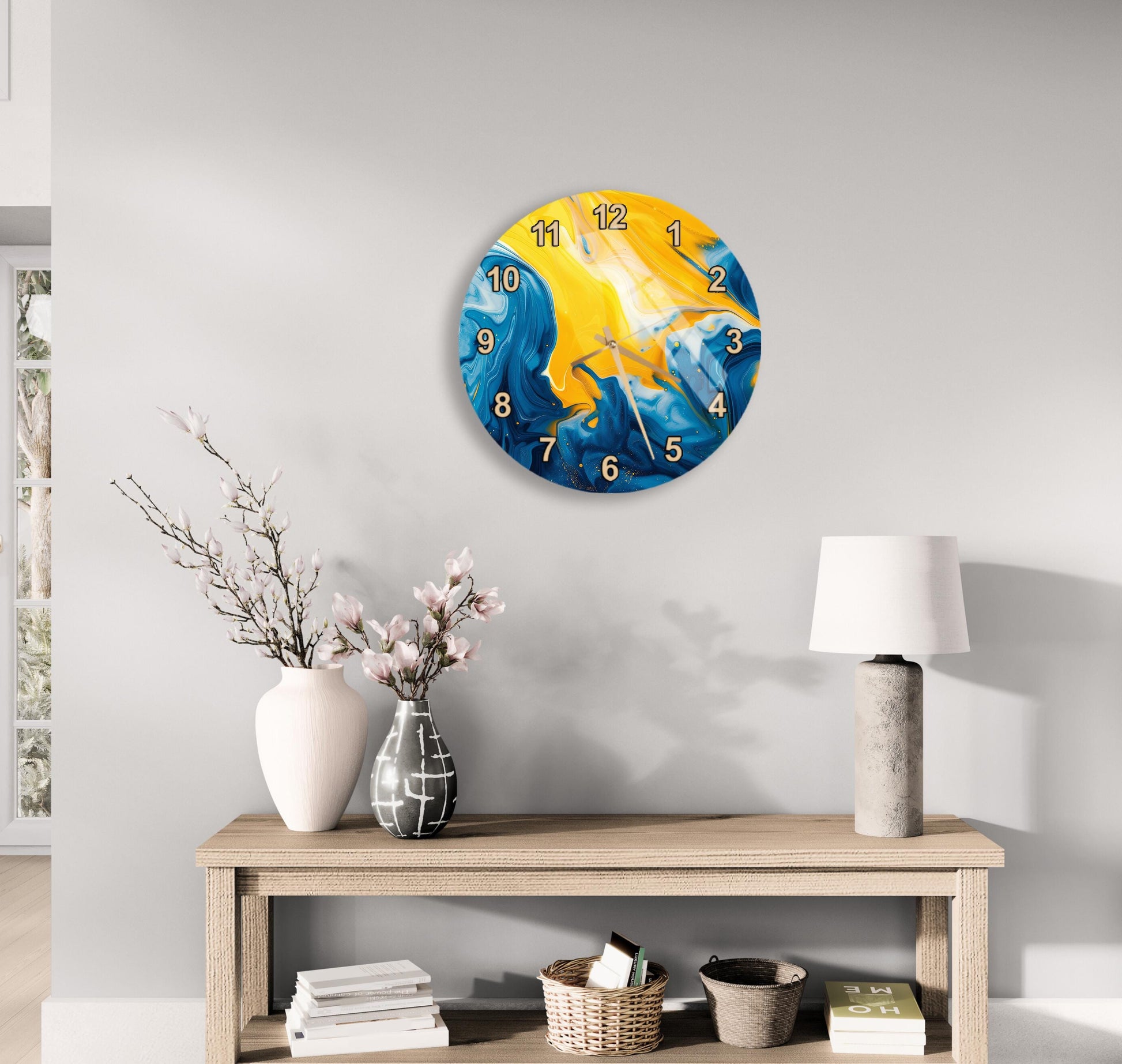 a modern clock with a blue and yellow design, mounted on a wall above a wooden table with a lamp and decorative items.