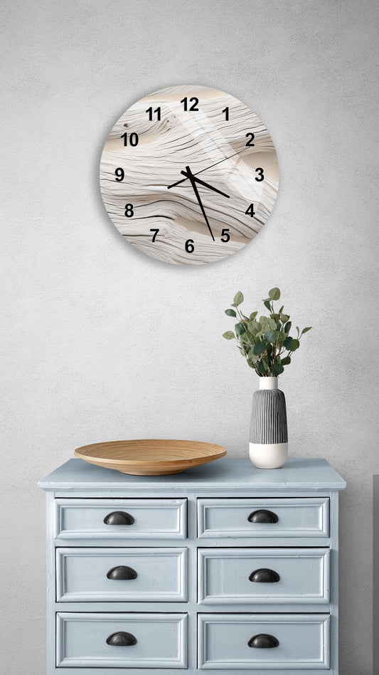 a wall clock with a marble-like design, mounted on a wall above a light blue wooden dresser with six drawers. The dresser also has a vase with greenery on it, and a wooden plate on top.
