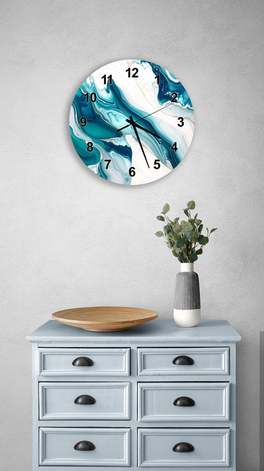 a wall clock with a blue and white marble design, mounted on a wall above a light blue dresser with six drawers. The dresser also has a vase with greenery on it, and a wooden tray on top.