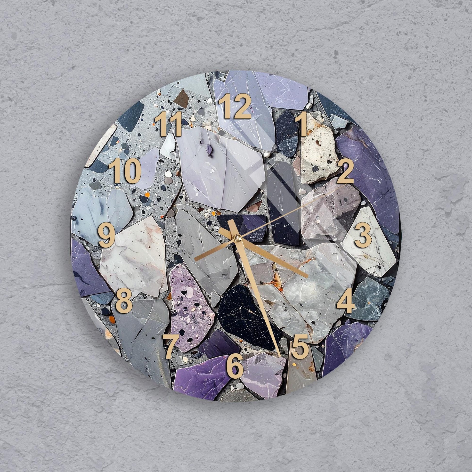 A wall clock with a mosaic design made up of various colored stones and pebbles, creating a unique and visually interesting pattern.