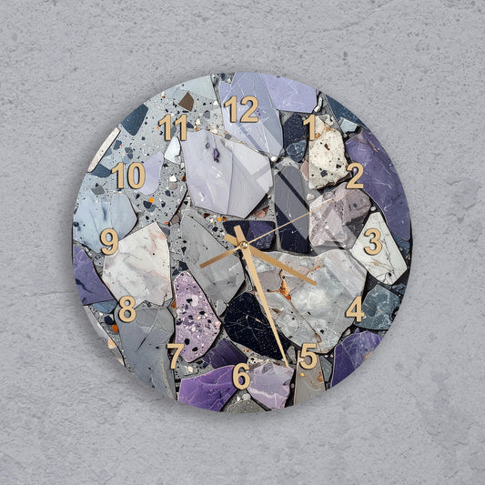 A wall clock with a mosaic design made up of various colored stones and pebbles, creating a unique and visually interesting pattern.