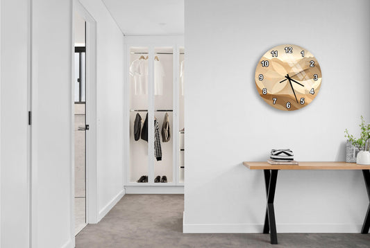 a modern hallway with a large gold-colored clock on the wall, a wooden console table, and a closet with hanging clothes.