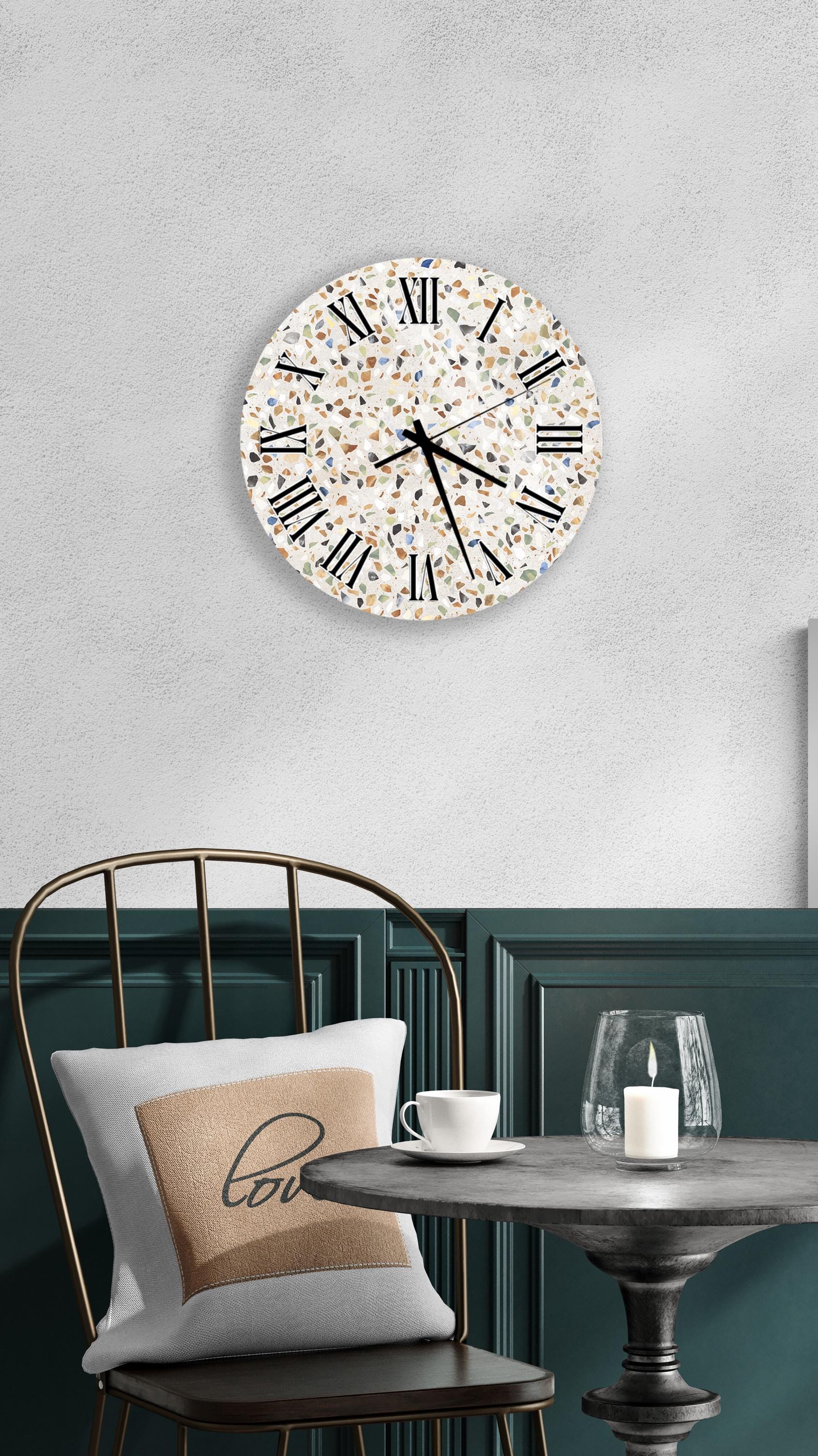 a modern interior design with a round wall clock, a black metal chair, a white table with a candle, and a beige pillow with the word "love" on it.