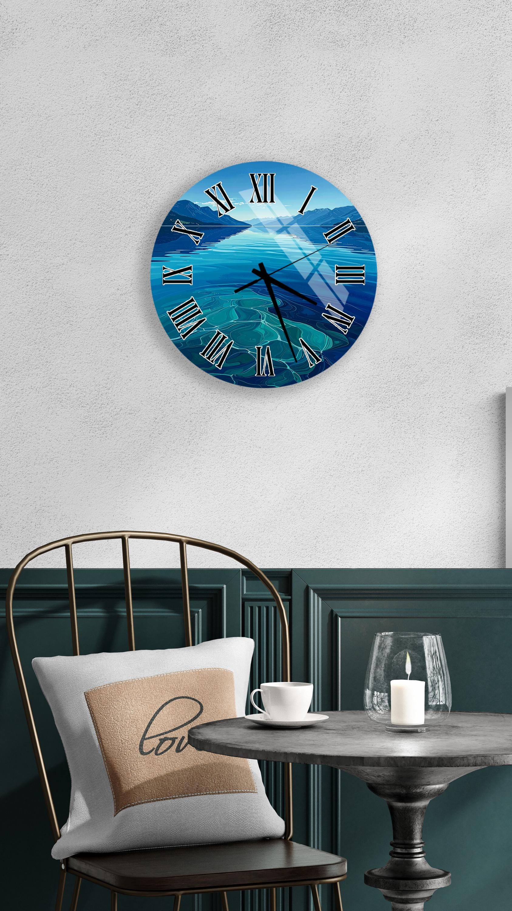 a wall clock with a blue ocean scene, a white table with a candle and a cup, and a black chair with a pillow.