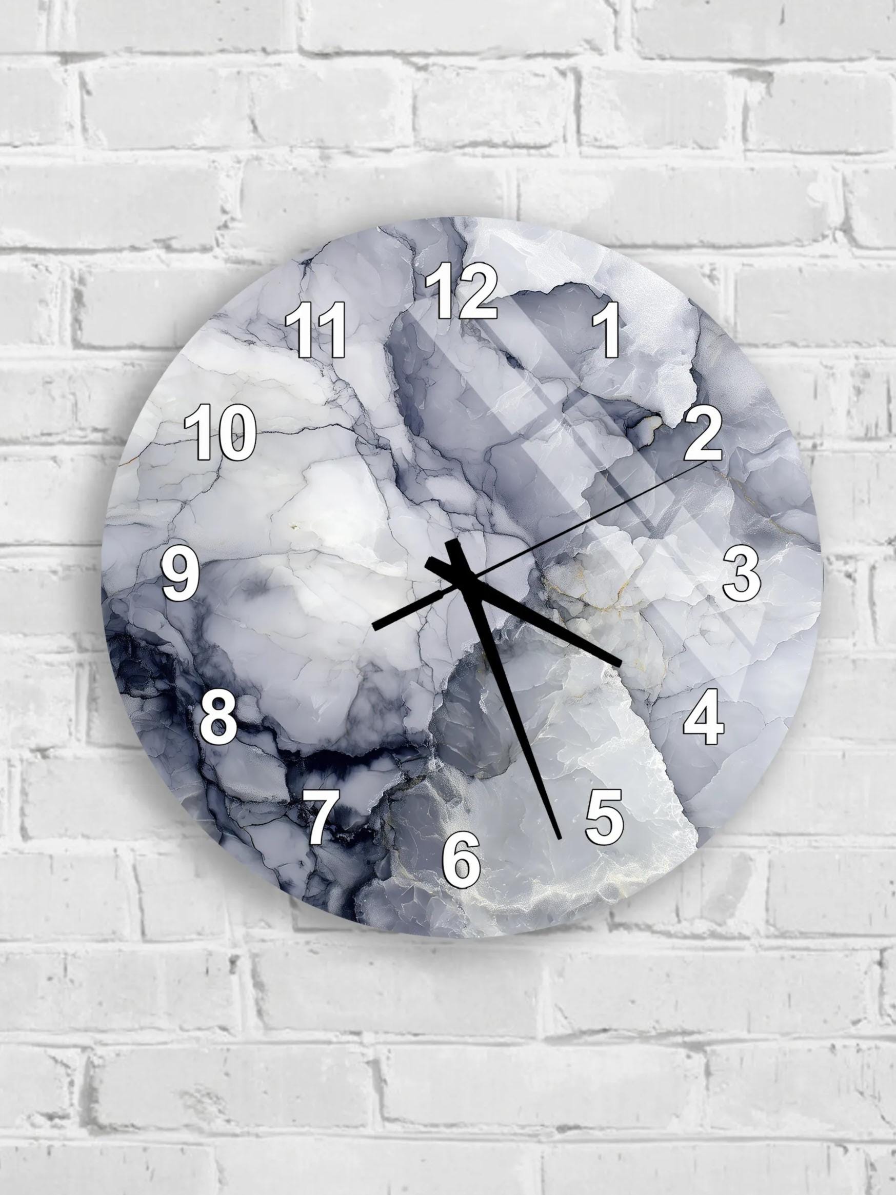 A wall clock with a marble-like design on its face, mounted on a white brick wall.