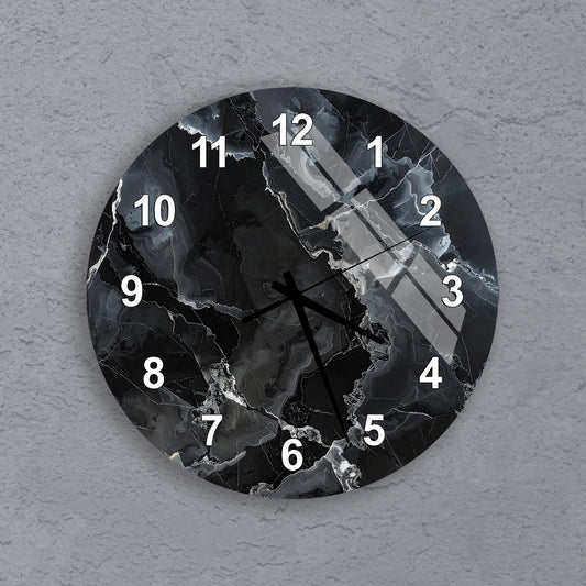 A black and white clock with a marble-like design on its face, mounted on a gray wall.