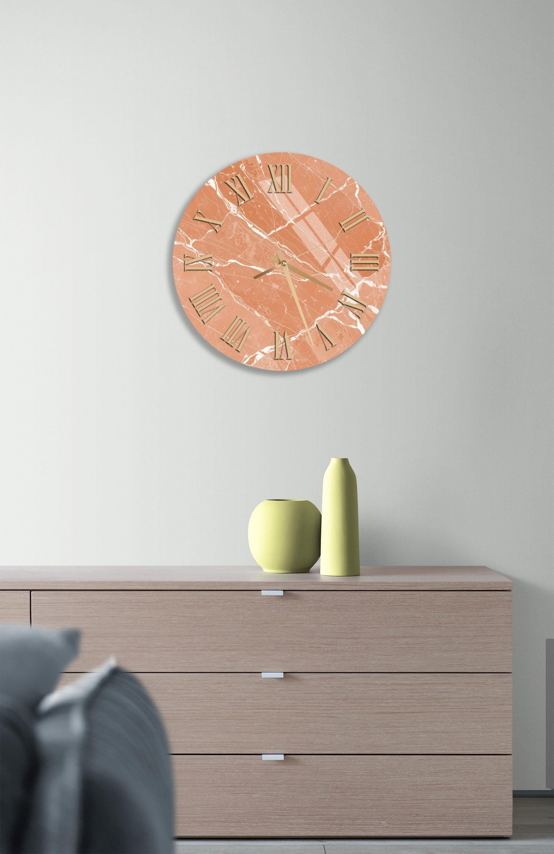 a modern living room with a wooden dresser, a round clock with a marble-like design, and a small green vase on the dresser.