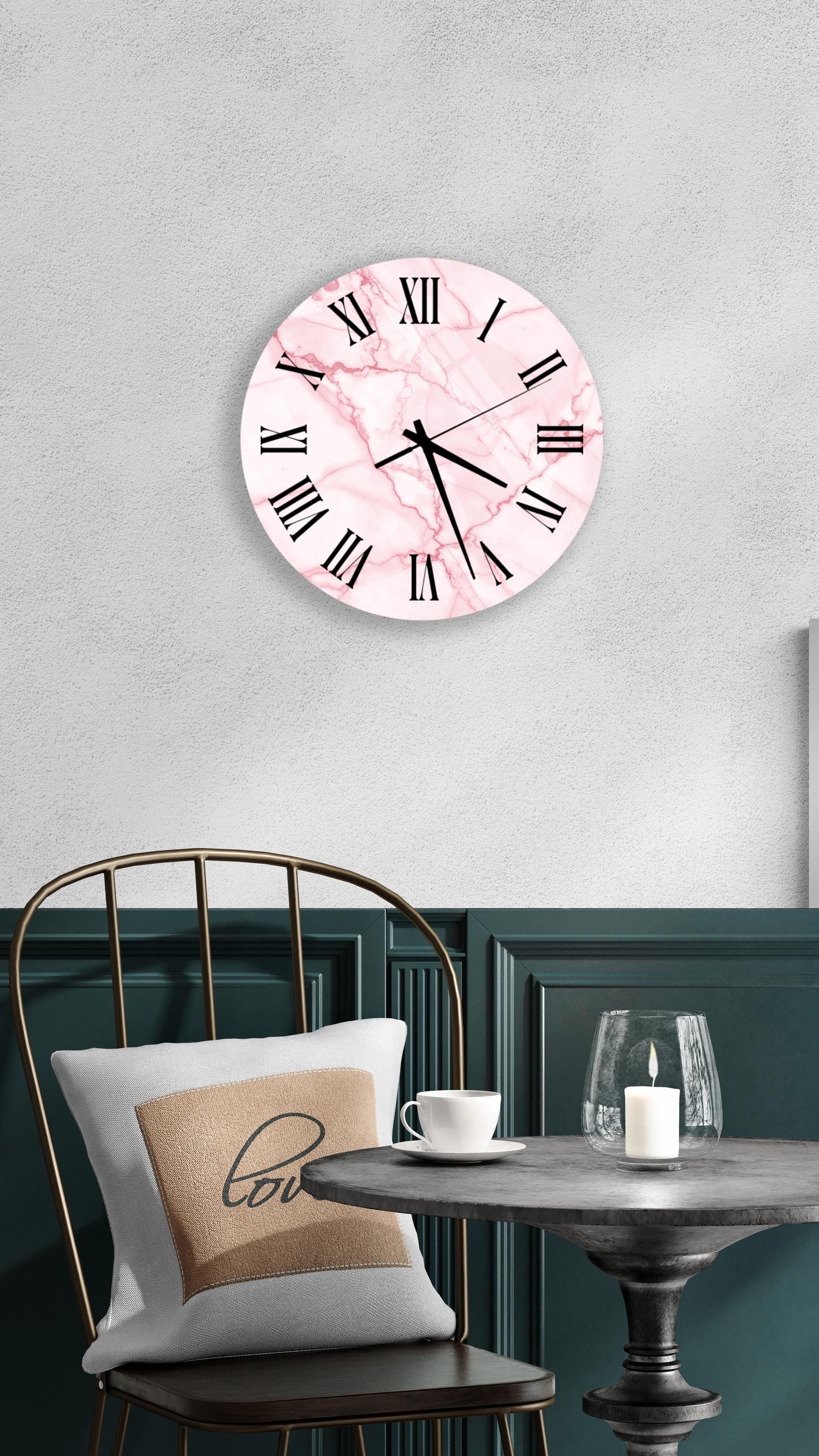 a modern and stylish interior design with a pink marble clock, a white table, and a gold chair.