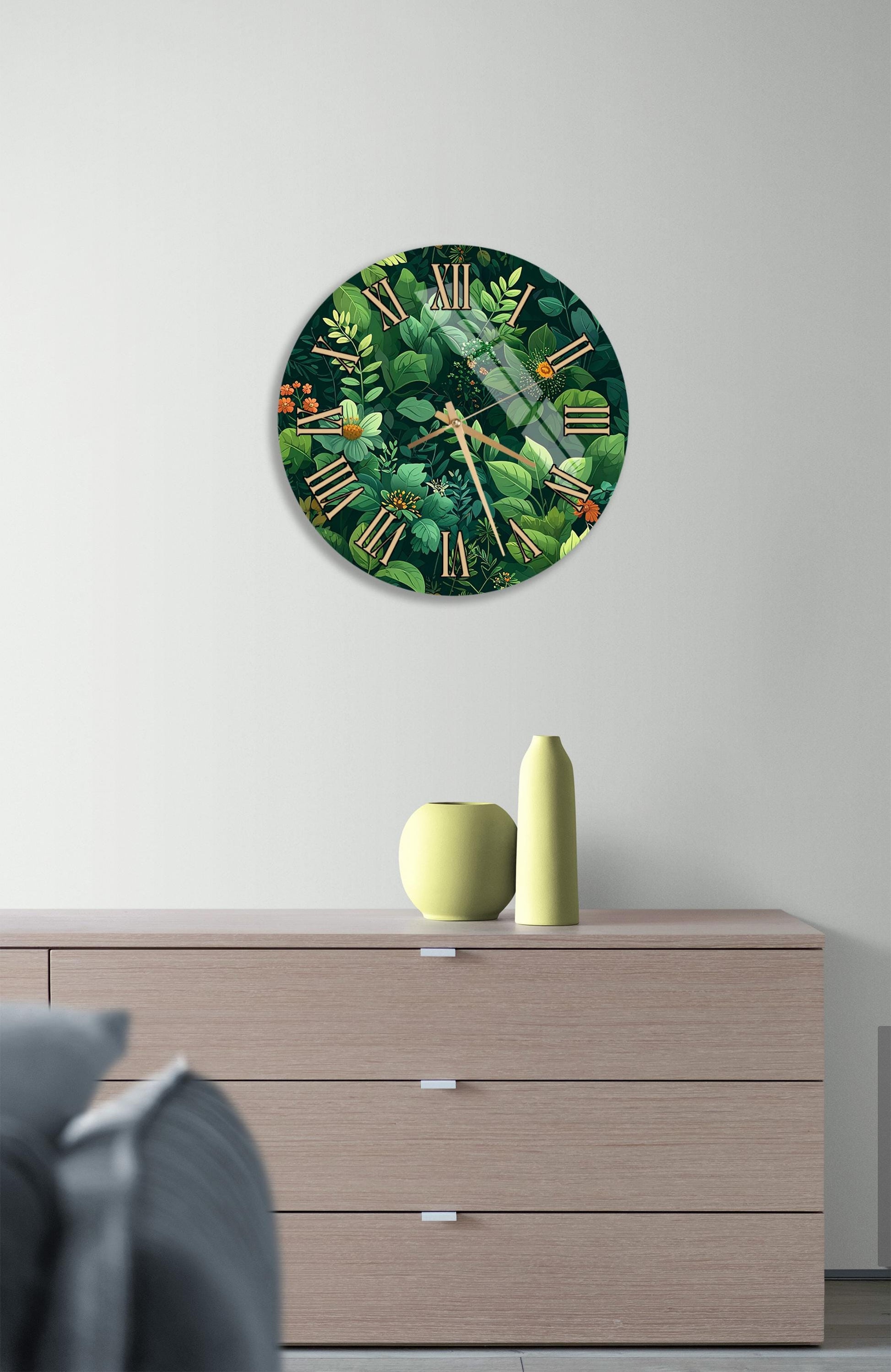 a clock with a green and brown design, hanging on a wall above a wooden dresser with three drawers.
