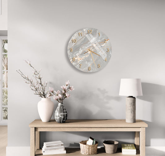 a modern and minimalist living room with a wooden console table, a round wall clock, and various decorative elements such as a vase with flowers, a lamp, and a stack of books.