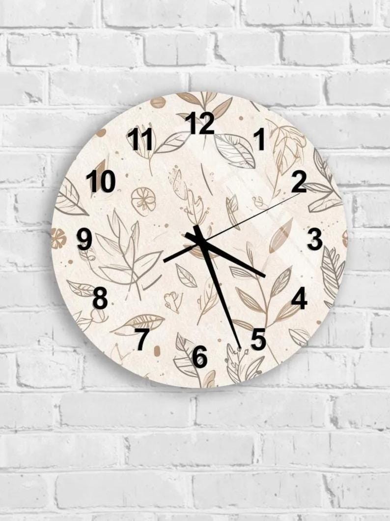 A round wall clock with a floral pattern on its face, mounted on a white brick wall.