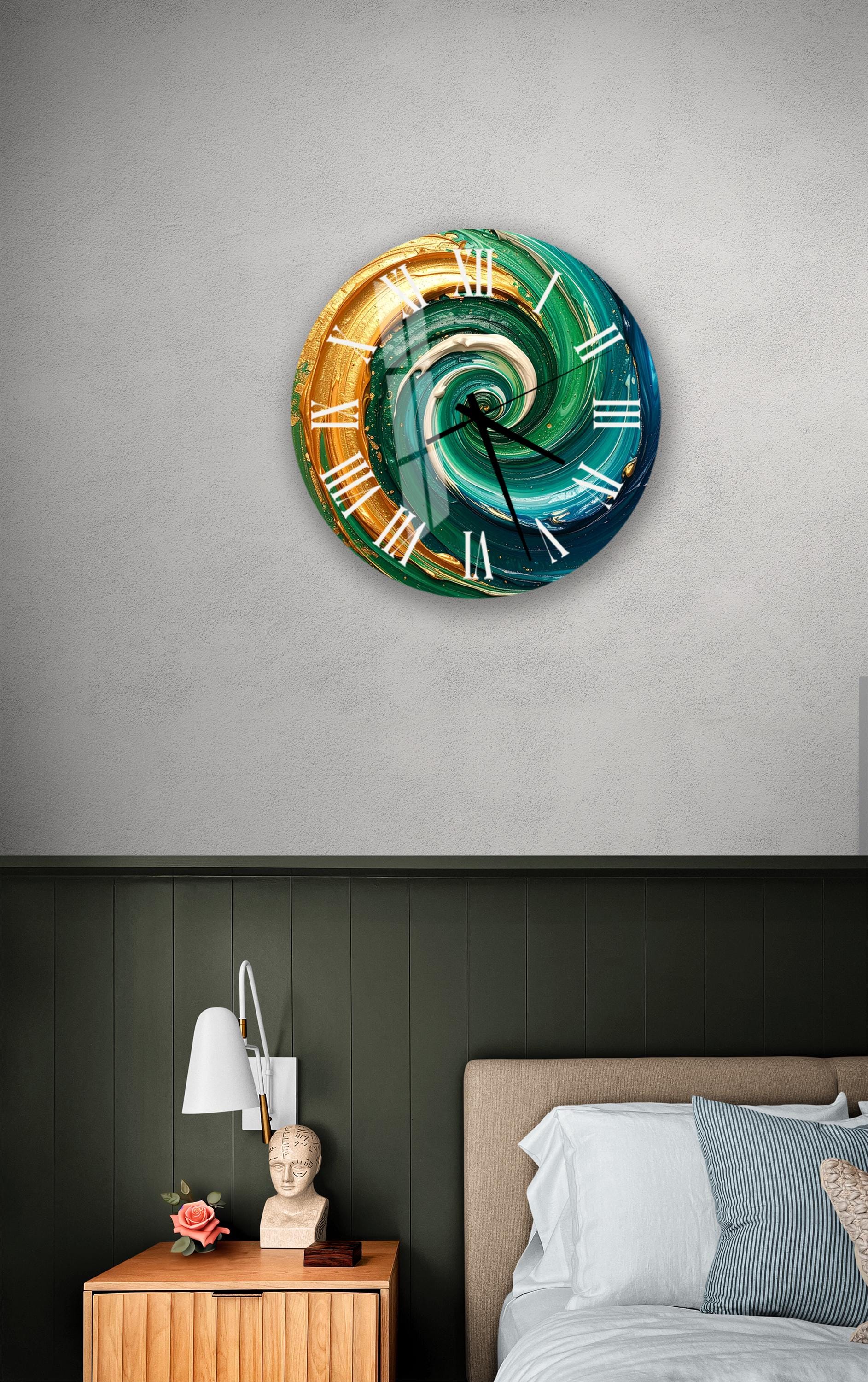 a bedroom setting with a large, colorful wall clock hanging on the wall above a bed. The clock has a swirling design in shades of blue, green, and orange. The room also includes a nightstand with a lamp and a small statue, as well as a bed with white sheets and a blue and white striped pillow.