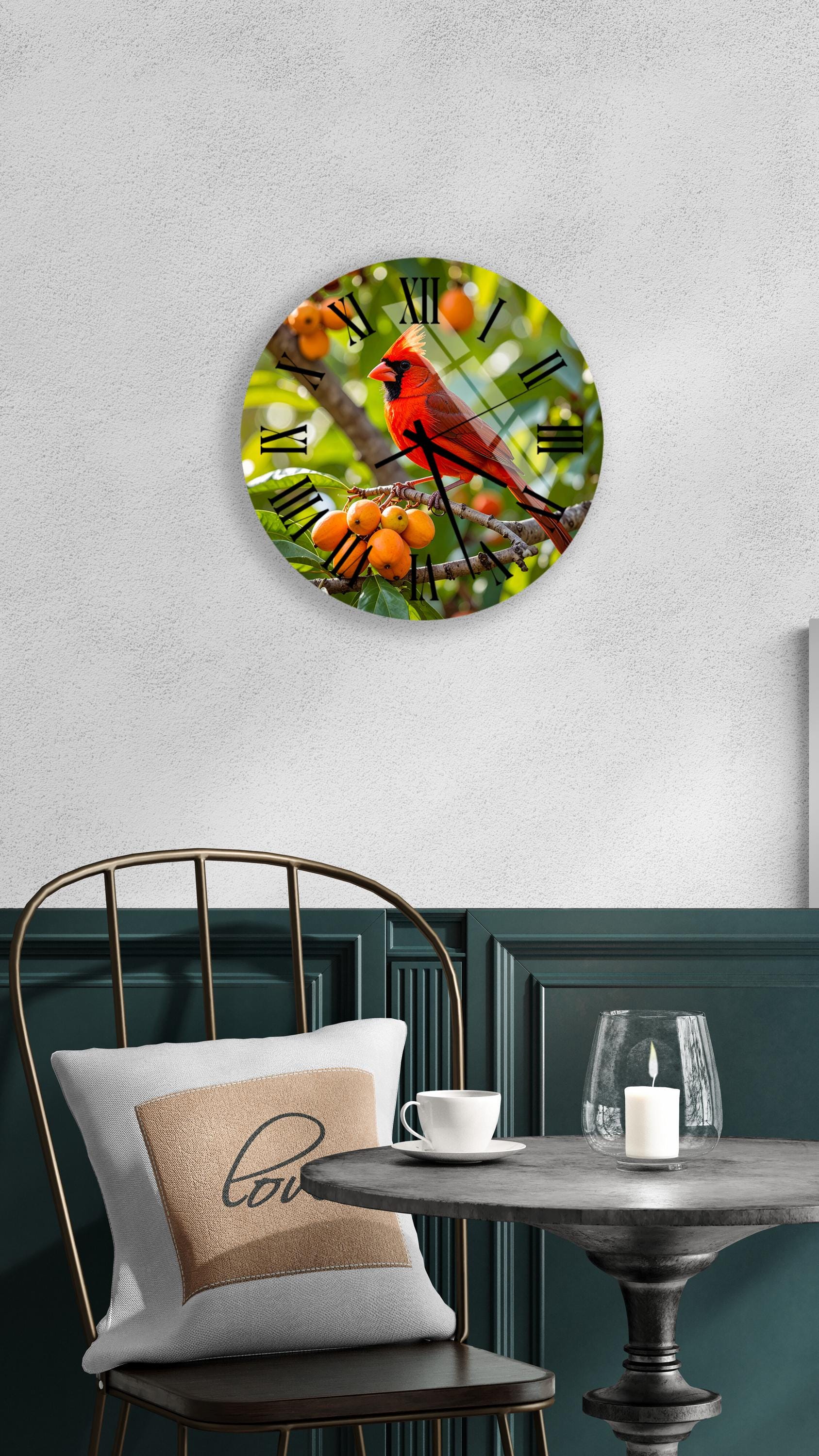 a round wall clock with a vibrant red cardinal perched on a branch, surrounded by orange berries, hanging on a white wall above a black metal chair.