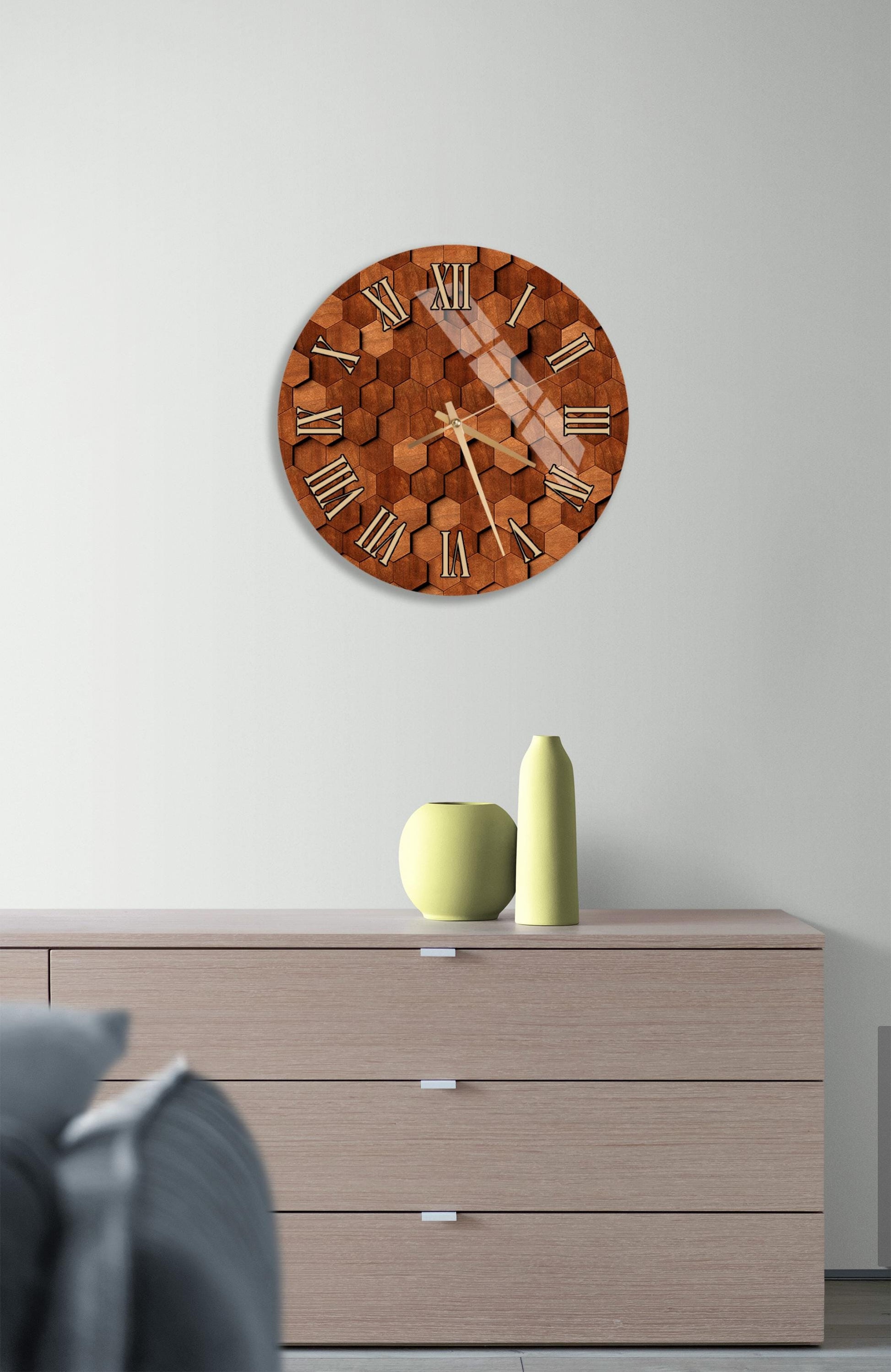 a wooden clock with a hexagonal pattern on its face, mounted on a wall above a wooden dresser with three drawers.
