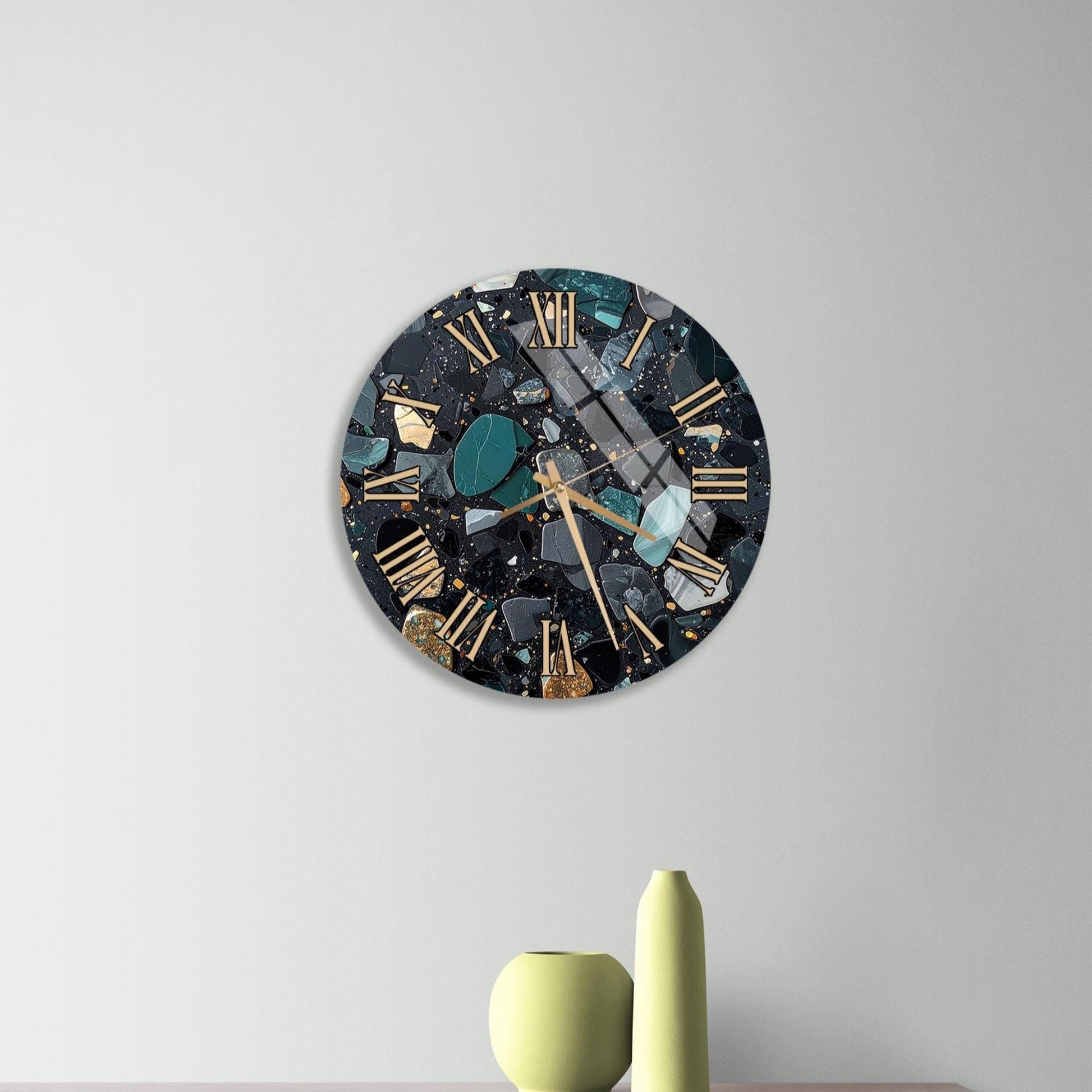 a modern clock with a black and gold design, mounted on a wall above a wooden dresser. The dresser has three drawers and contains a yellow vase and a small green sculpture.
