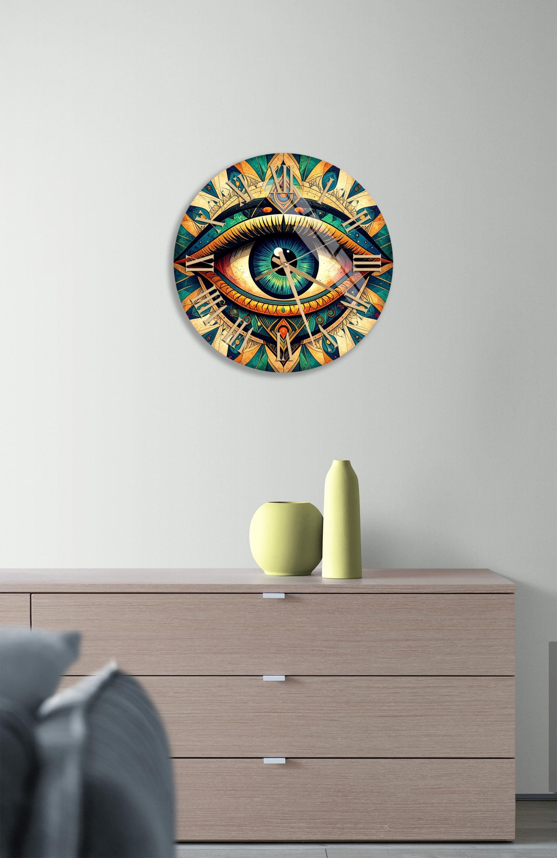 a large, colorful clock with an eye design on the face, mounted on a wall above a wooden dresser.