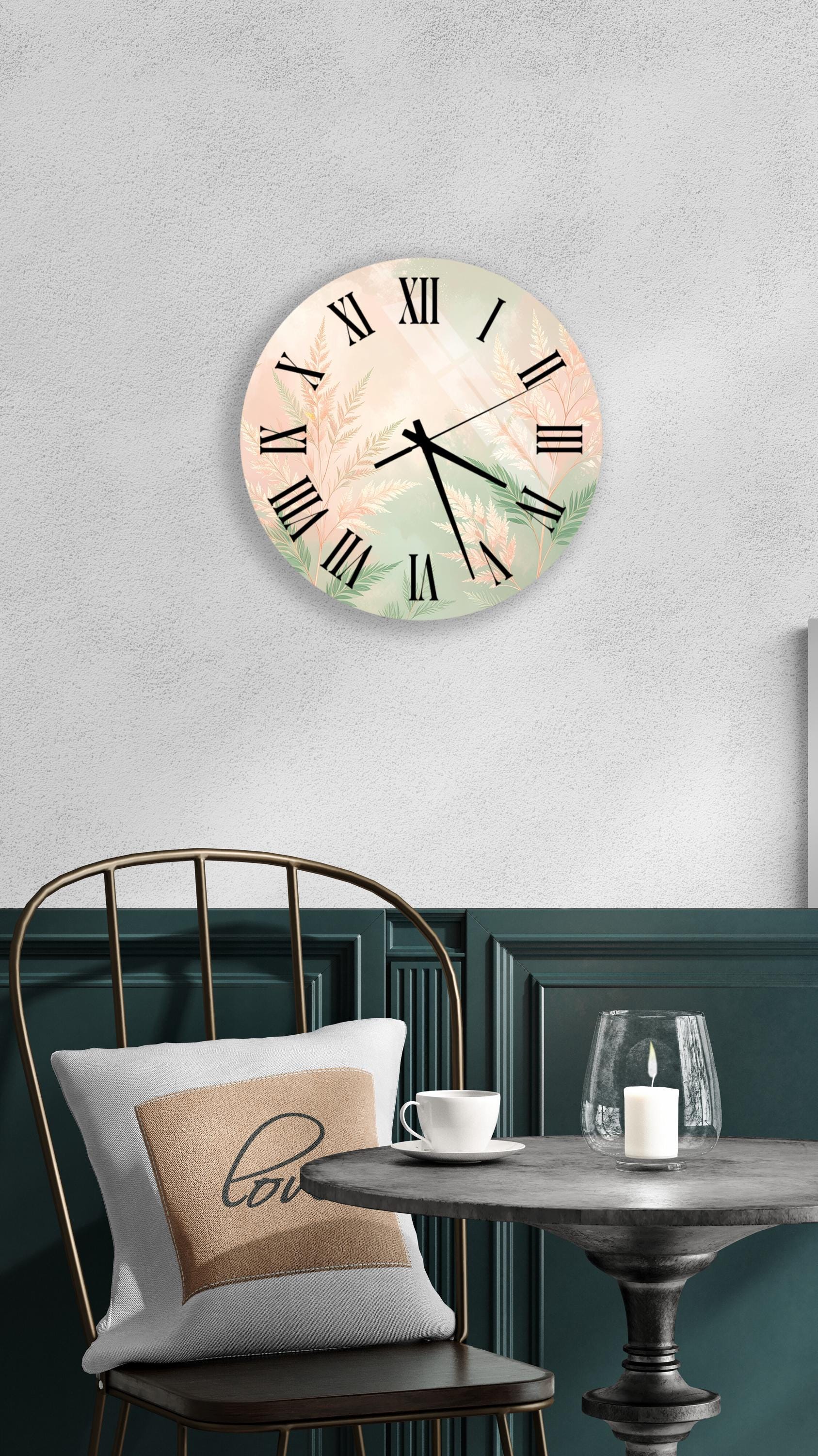 a wall clock with a floral design, a white table with a candle and a cup, and a green chair with a pillow.