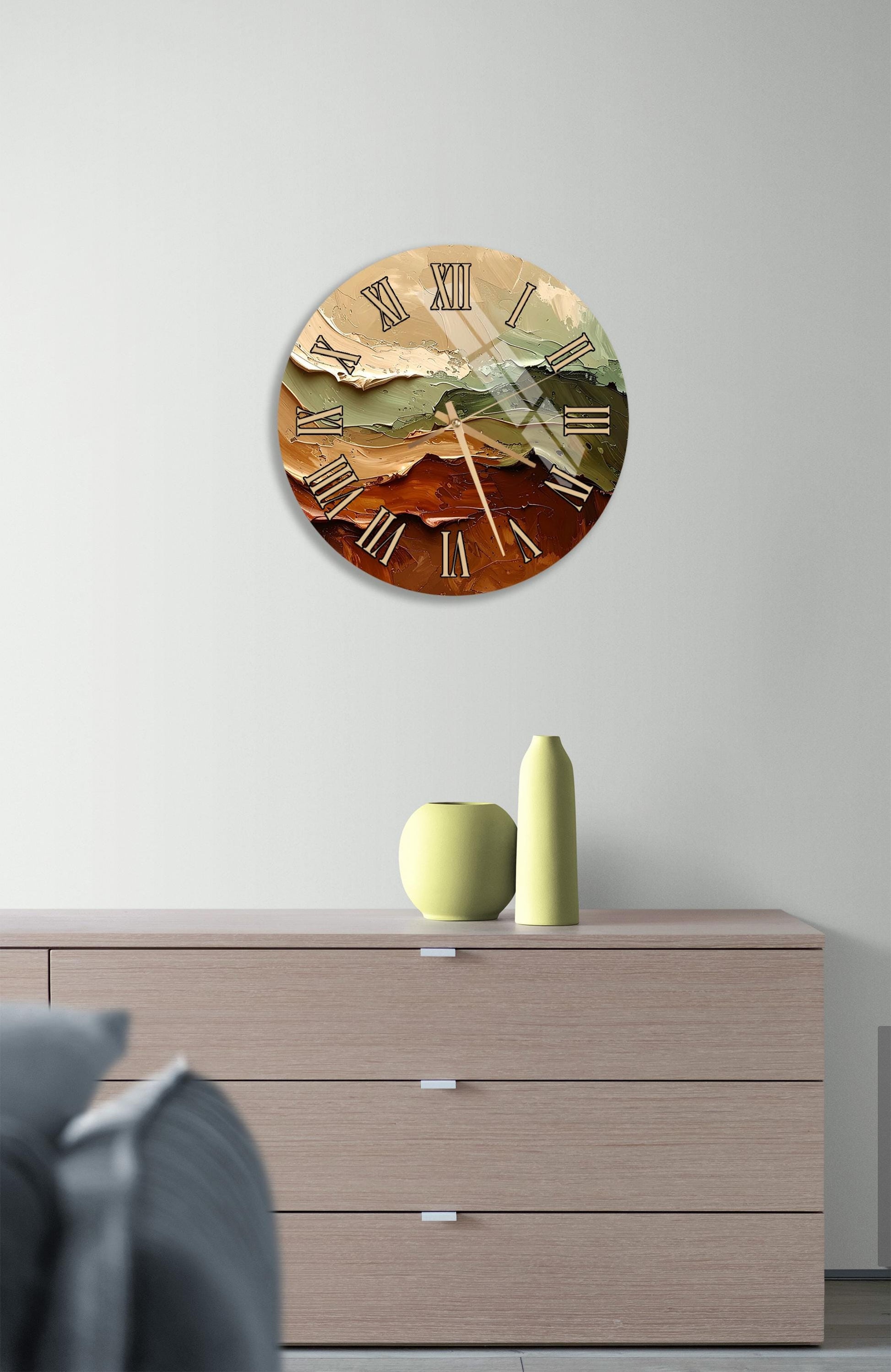 a wall clock with a brown and green color scheme, mounted on a wall above a wooden dresser. The dresser has three drawers and a vase on top.