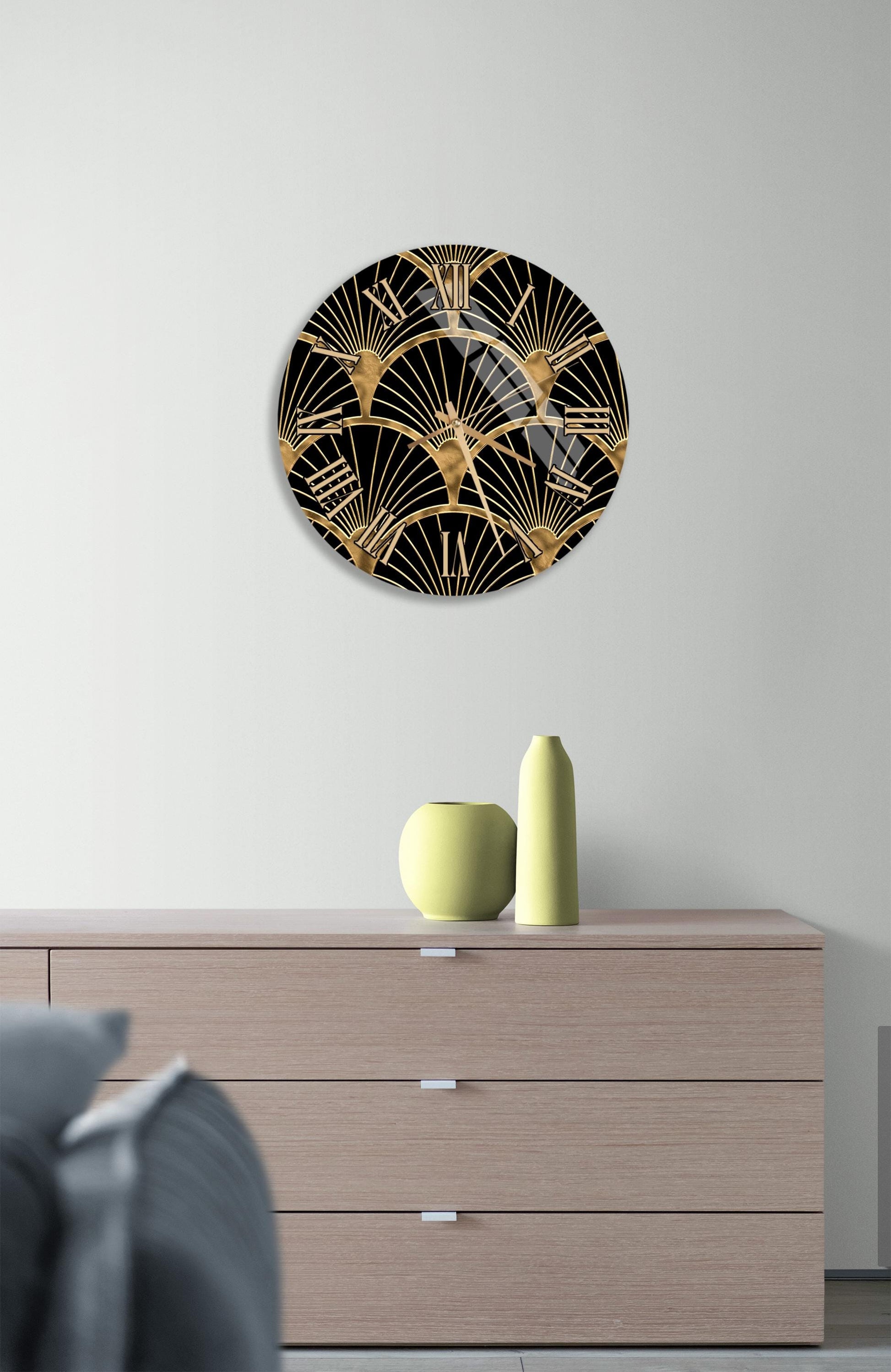 a modern interior design with a wooden dresser, a decorative vase, and a round wall art piece with a black and gold fan-like pattern.