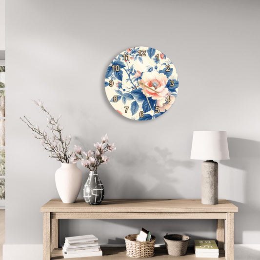 a wall clock with a floral design, a wooden table with a lamp, a vase with flowers, and some books on a shelf.