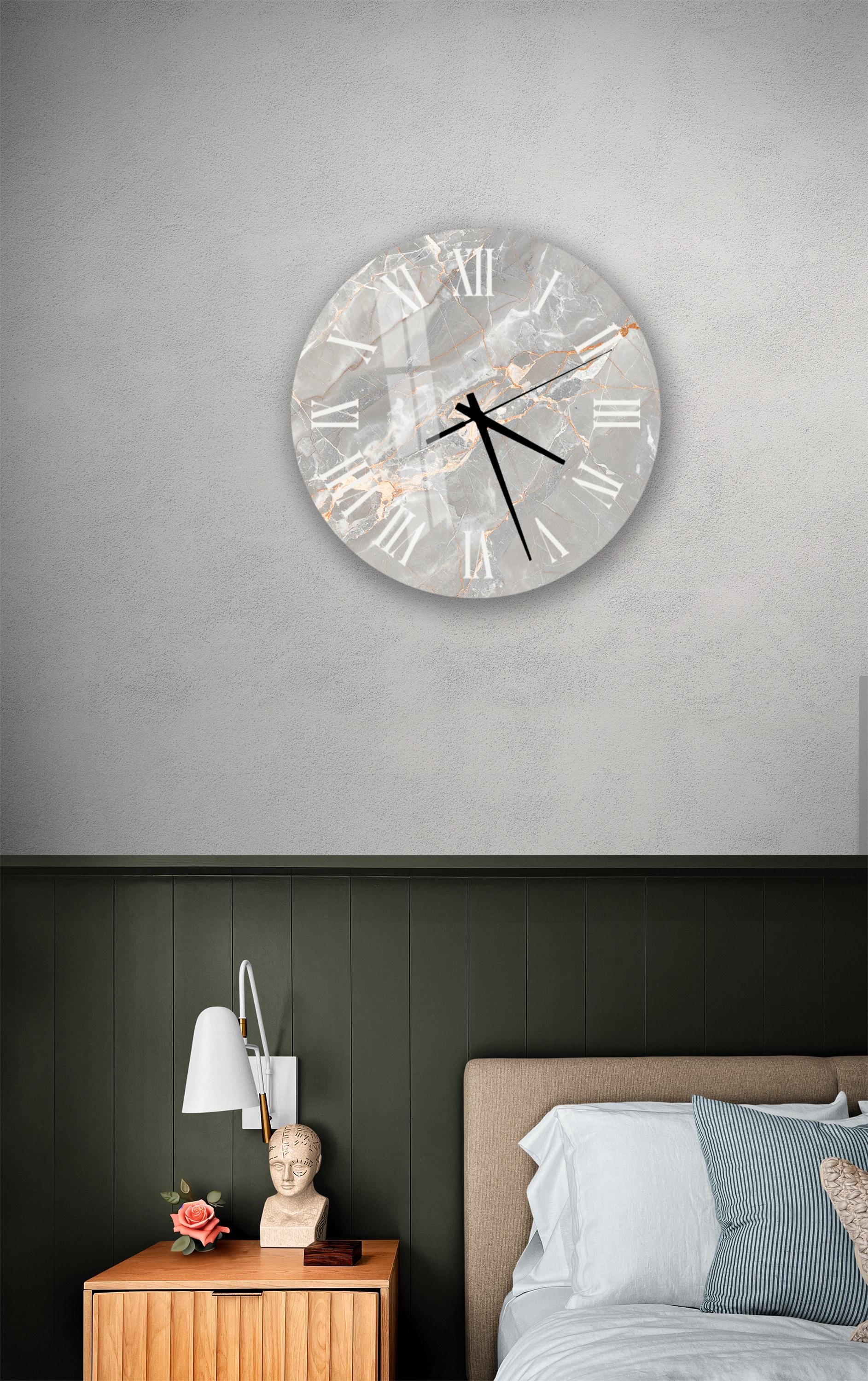 a bedroom setting with a large wall clock, a wooden nightstand, and a bed with white pillows.